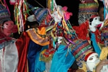 Close-up of vibrant costumes sparkling under festival lights during an Afro carnival.