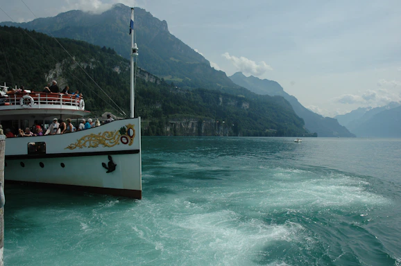 A vibrant photo of tourists enjoying a boat ride on Lago Chungara with snow-capped mountains in the background.