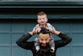 man in black leather jacket carrying boy in black leather jacket