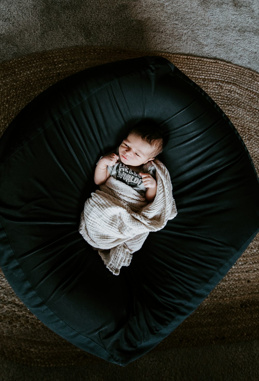 girl in white sweater and black pants lying on black round bed