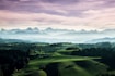 green grass field near green trees and mountains during daytime
