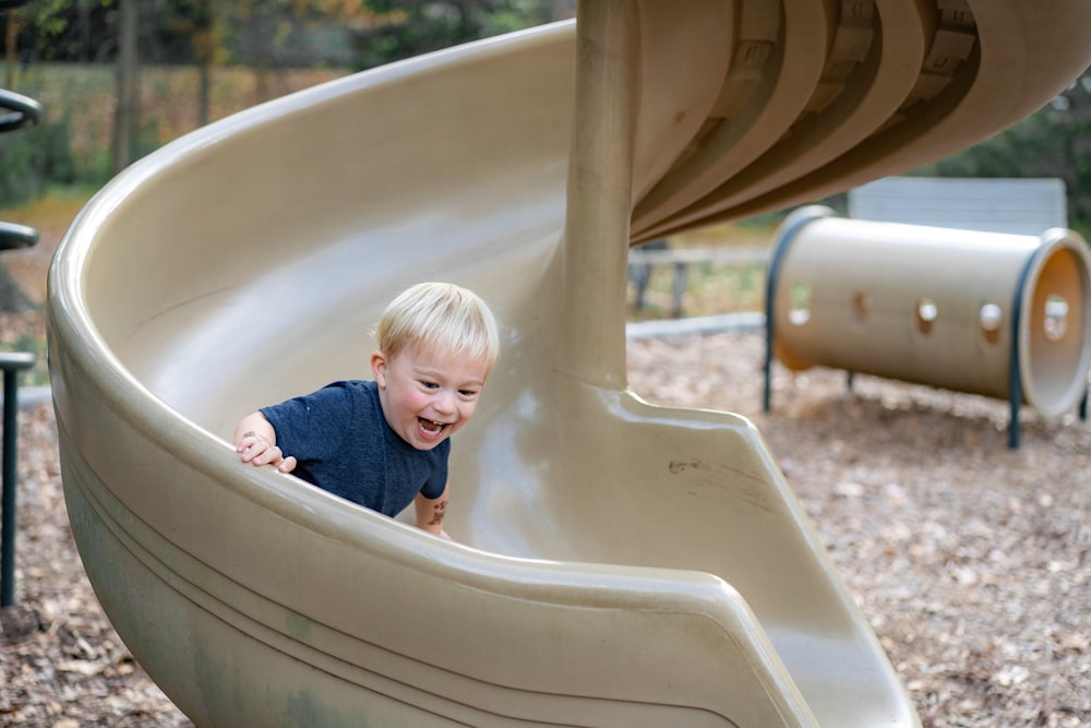 boy in blue shirt in white bathtub