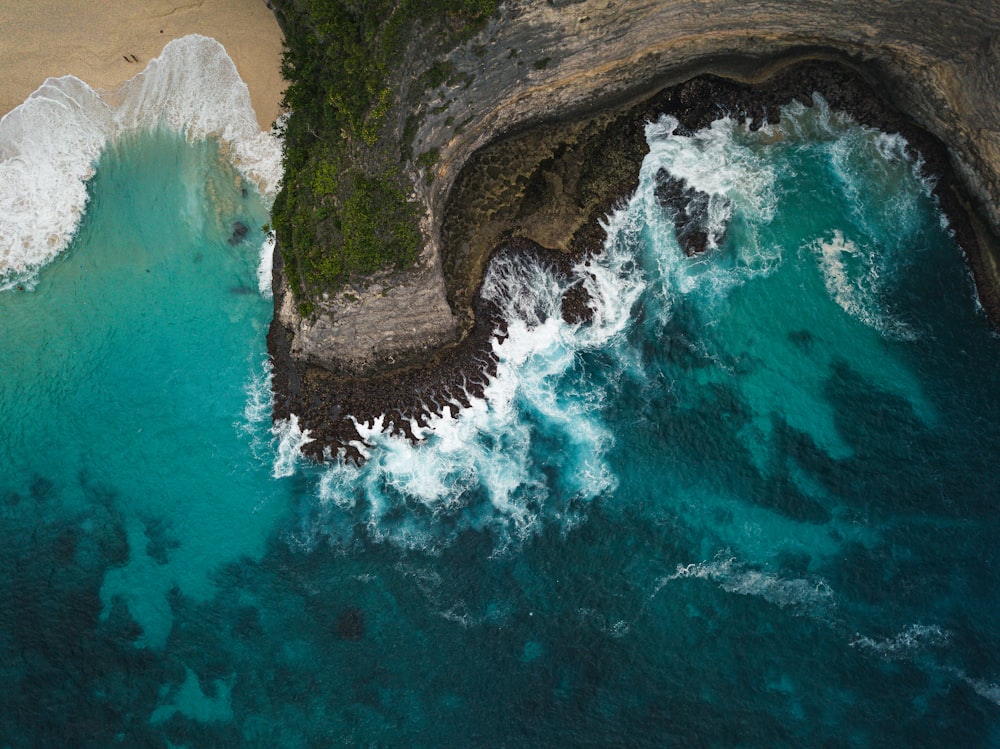 brown rock formation beside body of water during daytime