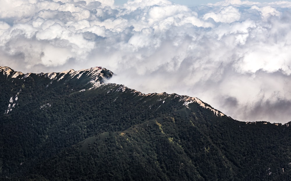 green and black mountain under white clouds during daytime