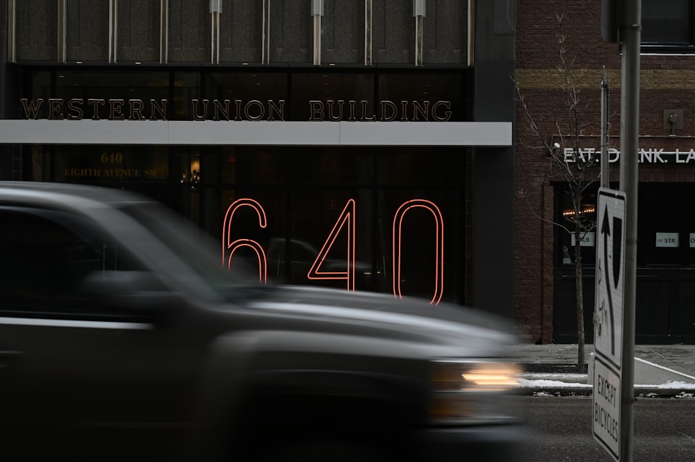 black car on road near brown building during night time