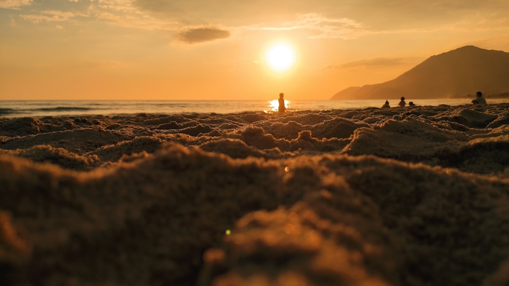 夕暮れ時の海岸に立つ人のシルエット