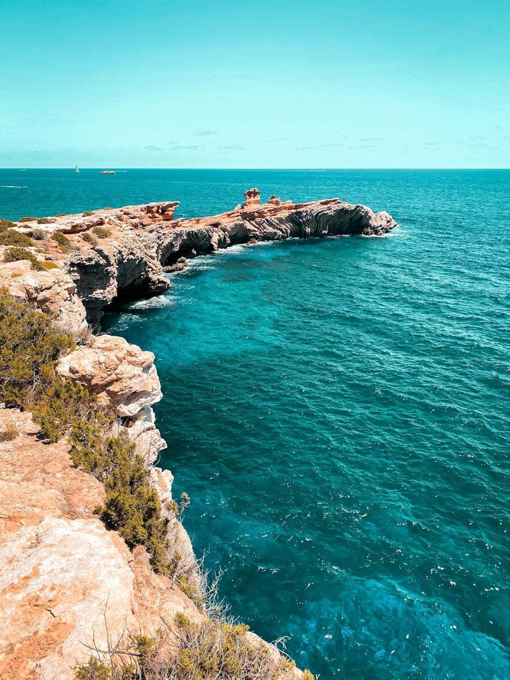 ein Gewässer, das sich neben einer Klippe befindet