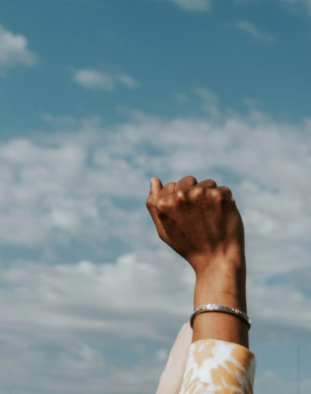 person wearing gold bracelet and white bracelet