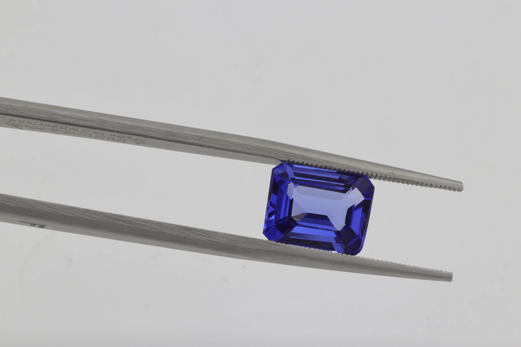 Blue faceted gemstone on a light background