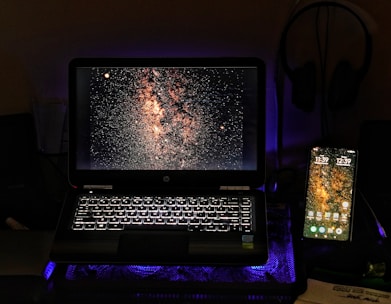 Mac and PC devices connected wirelessly under a starry vintage digital sky.