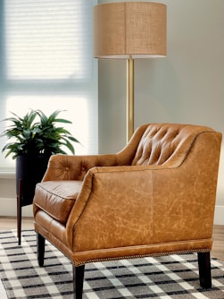 brown sofa chair near window