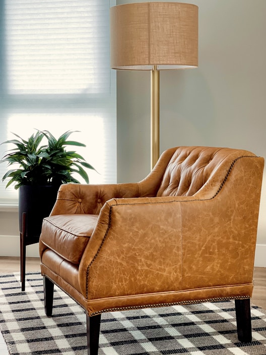 brown sofa chair near window