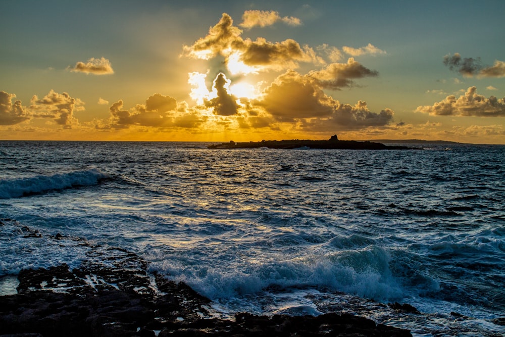 ondas do oceano batendo na costa durante o pôr do sol