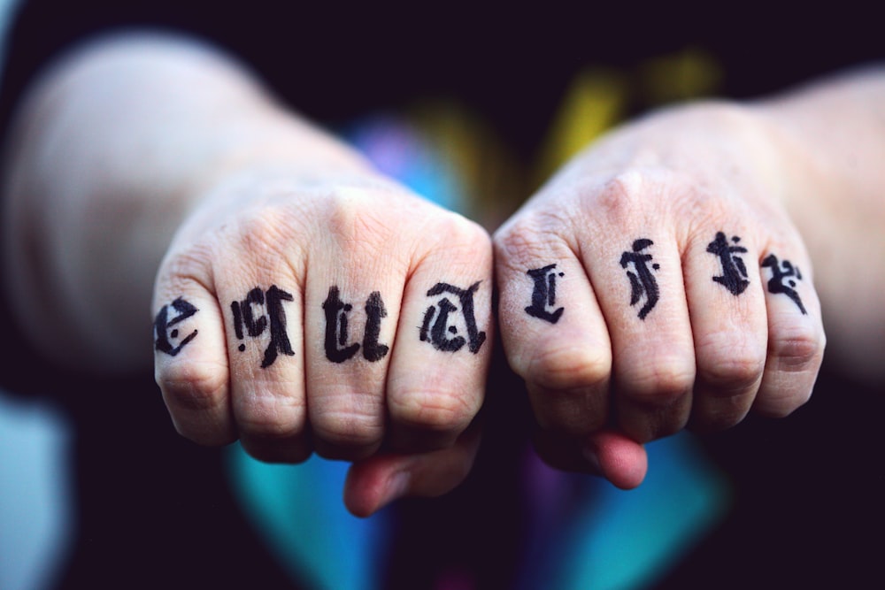 persons hand with black tattoo