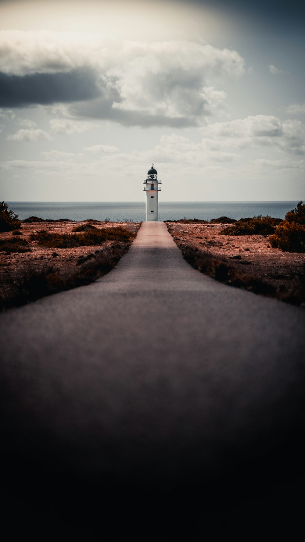 white and brown lighthouse near body of water during daytime