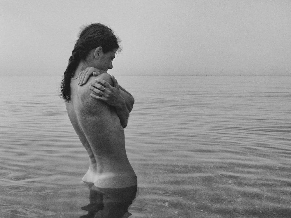 woman in body of water in grayscale photography