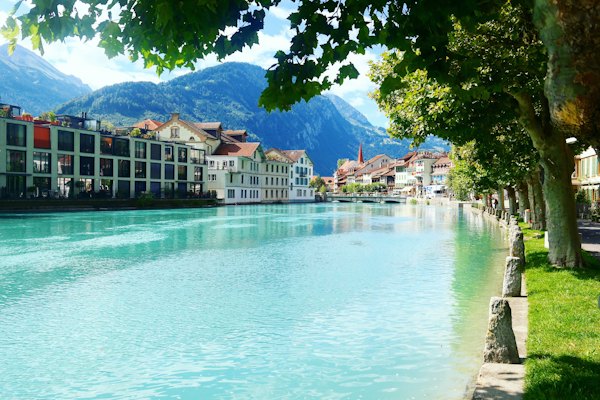 Green and white house near green trees and body of water during daytime — Interlaken & the Bernese Oberland, Switzerland