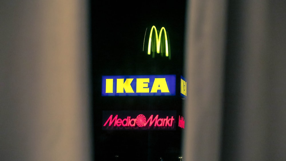 a neon sign is seen through a window