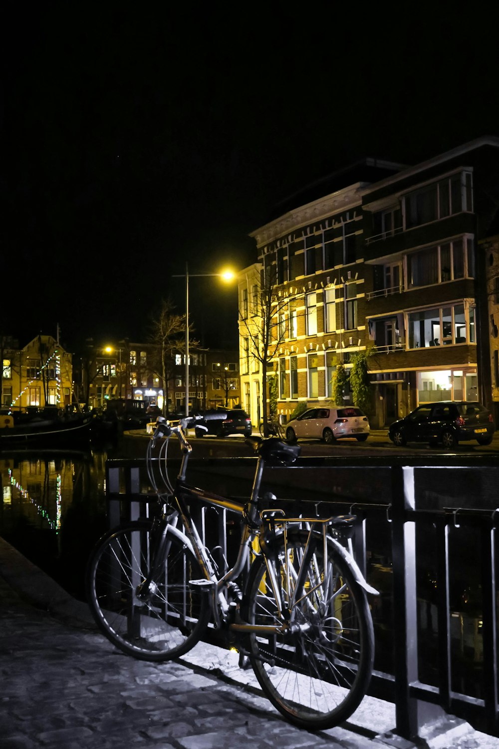 black and silver bicycle parked beside black steel fence during night time