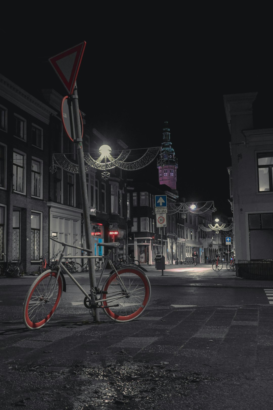 red bicycle parked on sidewalk during night time
