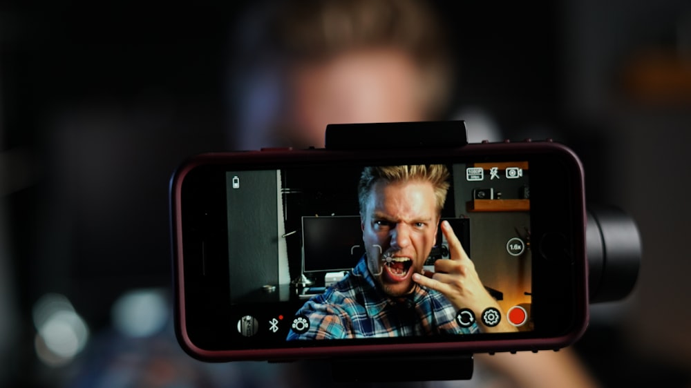 man in black and white plaid shirt holding black tablet computer