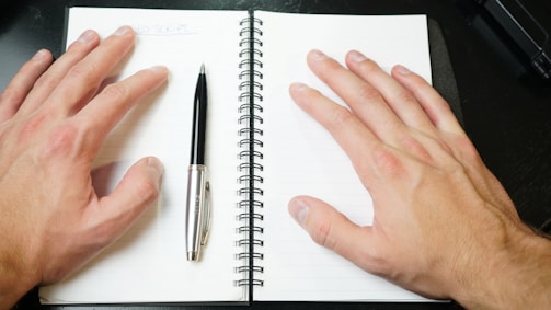 silver and black click pen on white notebook
