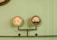 A pair of vintage-style gauges attached to a metal pipe system against a pale green background. The left gauge appears to be a pressure meter, while the right one displays increments and some text, likely indicating measurements.