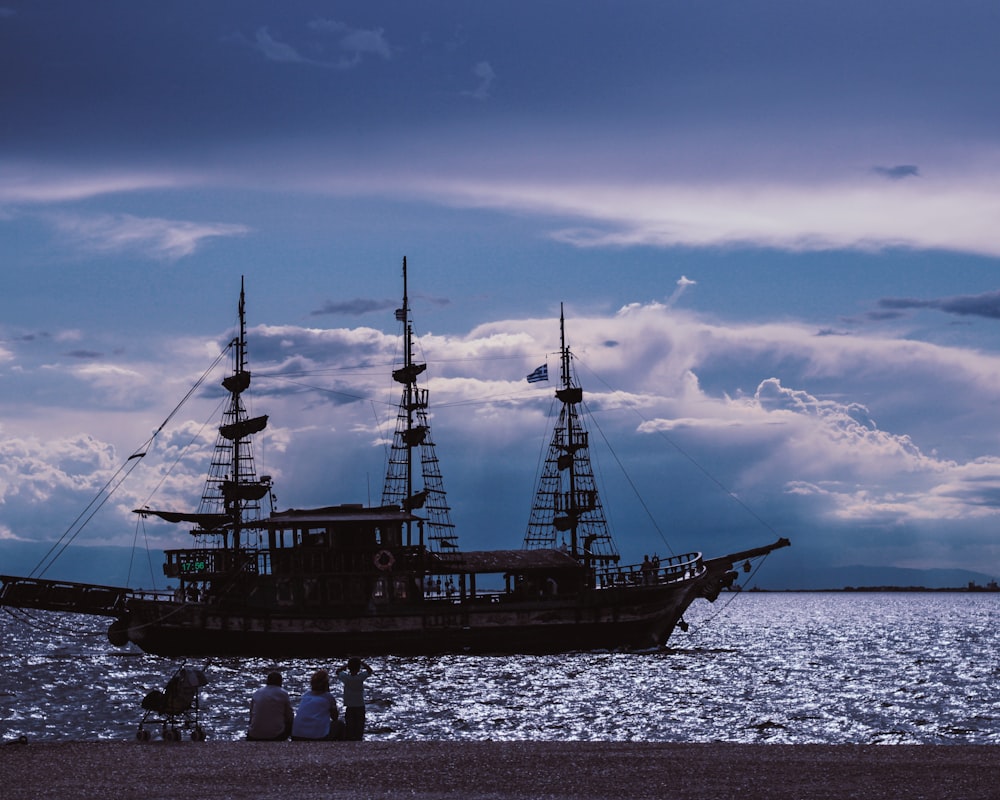 black ship on sea under blue sky during daytime