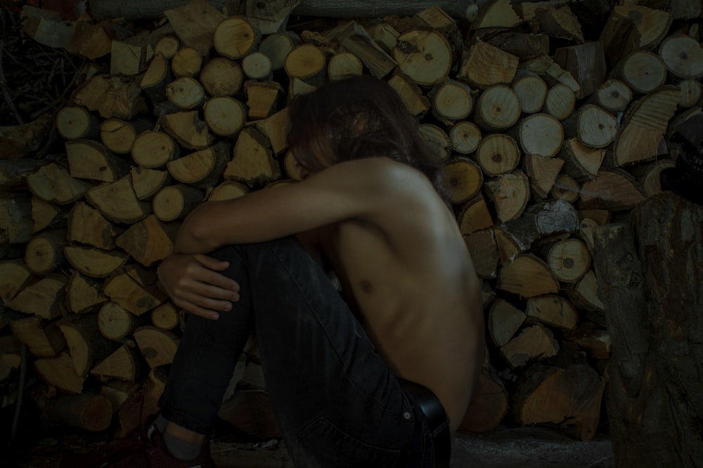 topless man in black pants lying on brown and black brick wall