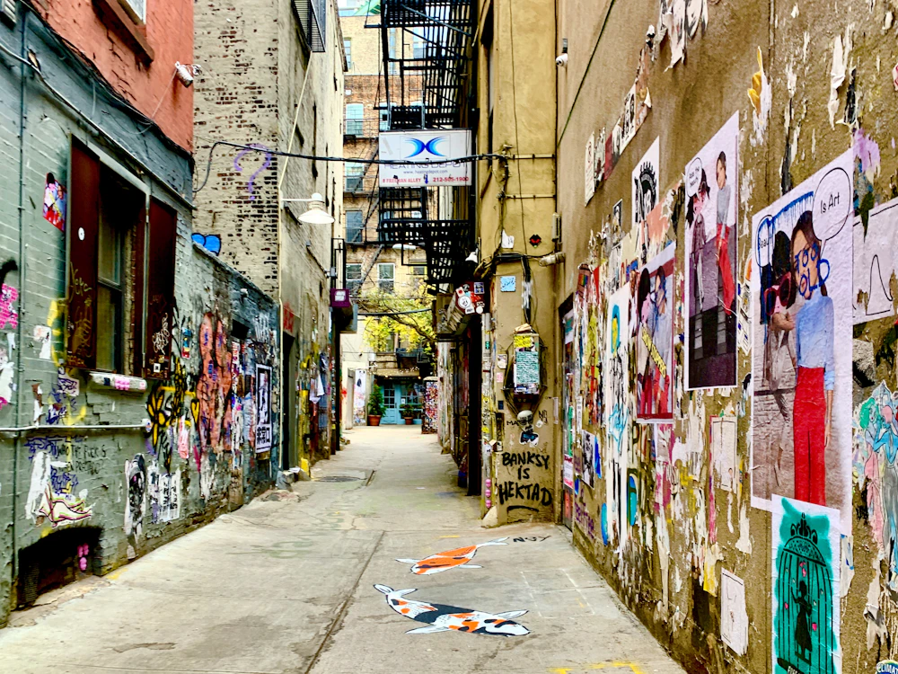 Narrow alley layered with posters, worn surfaces, and city texture.