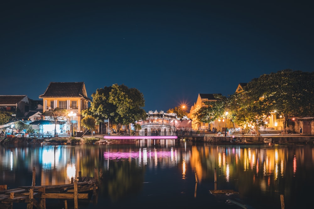 brown and white house near body of water during night time