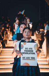 woman in blue shirt holding white paper