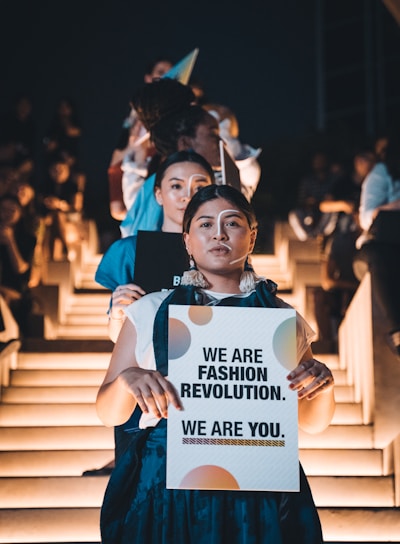 woman in blue shirt holding white paper