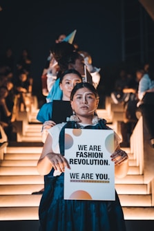 woman in blue shirt holding white paper