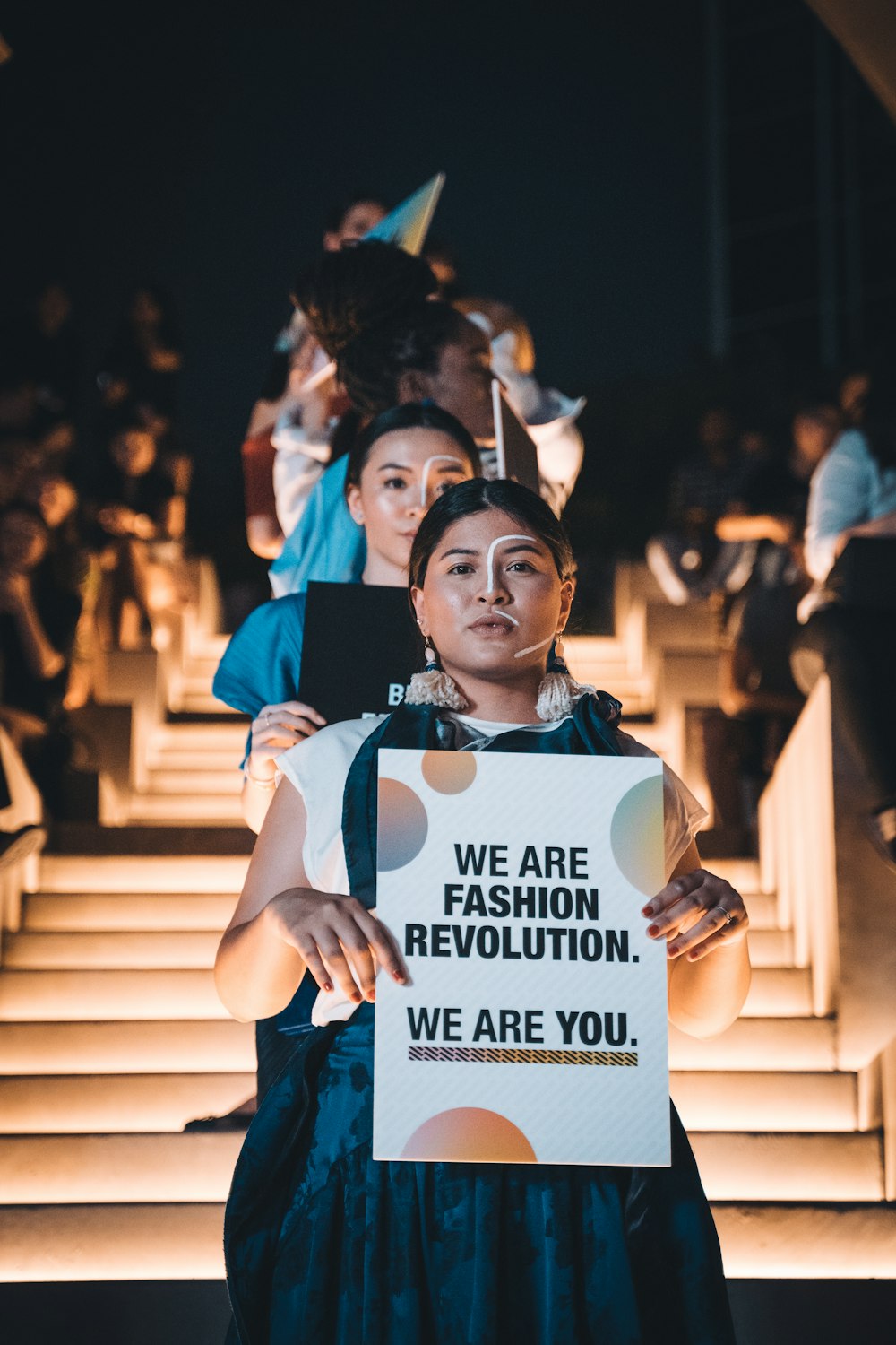 woman in blue shirt holding white paper