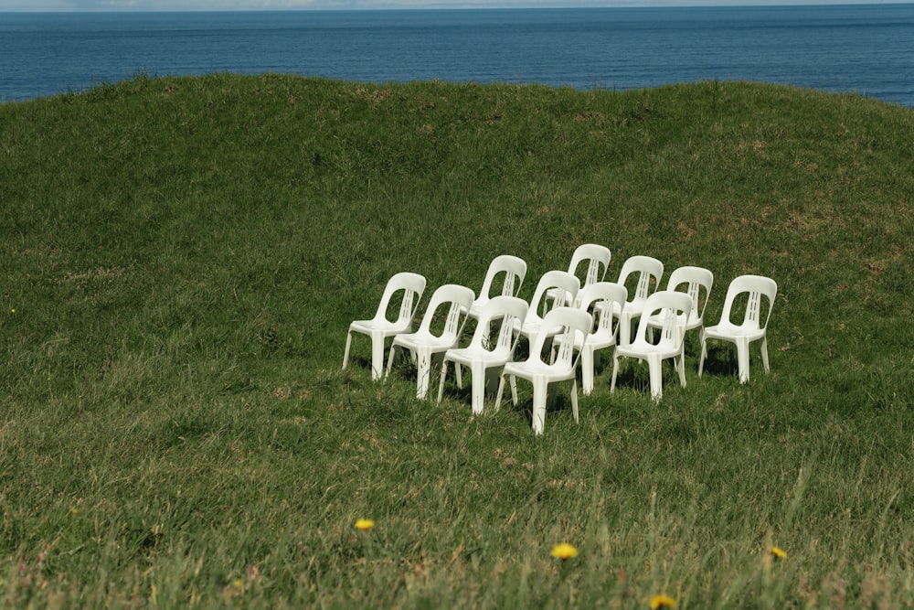 white plastic chairs on green grass field