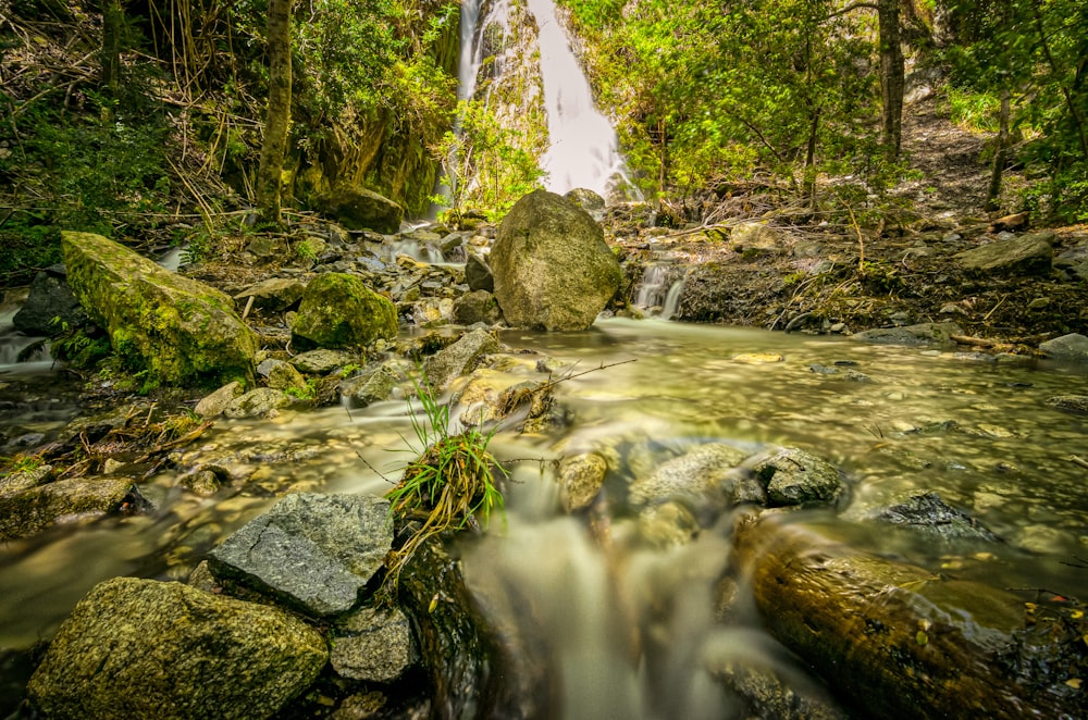 water falls on rocky shore during daytime