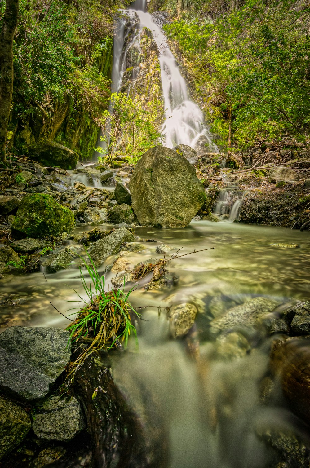 water falls on rocky shore during daytime