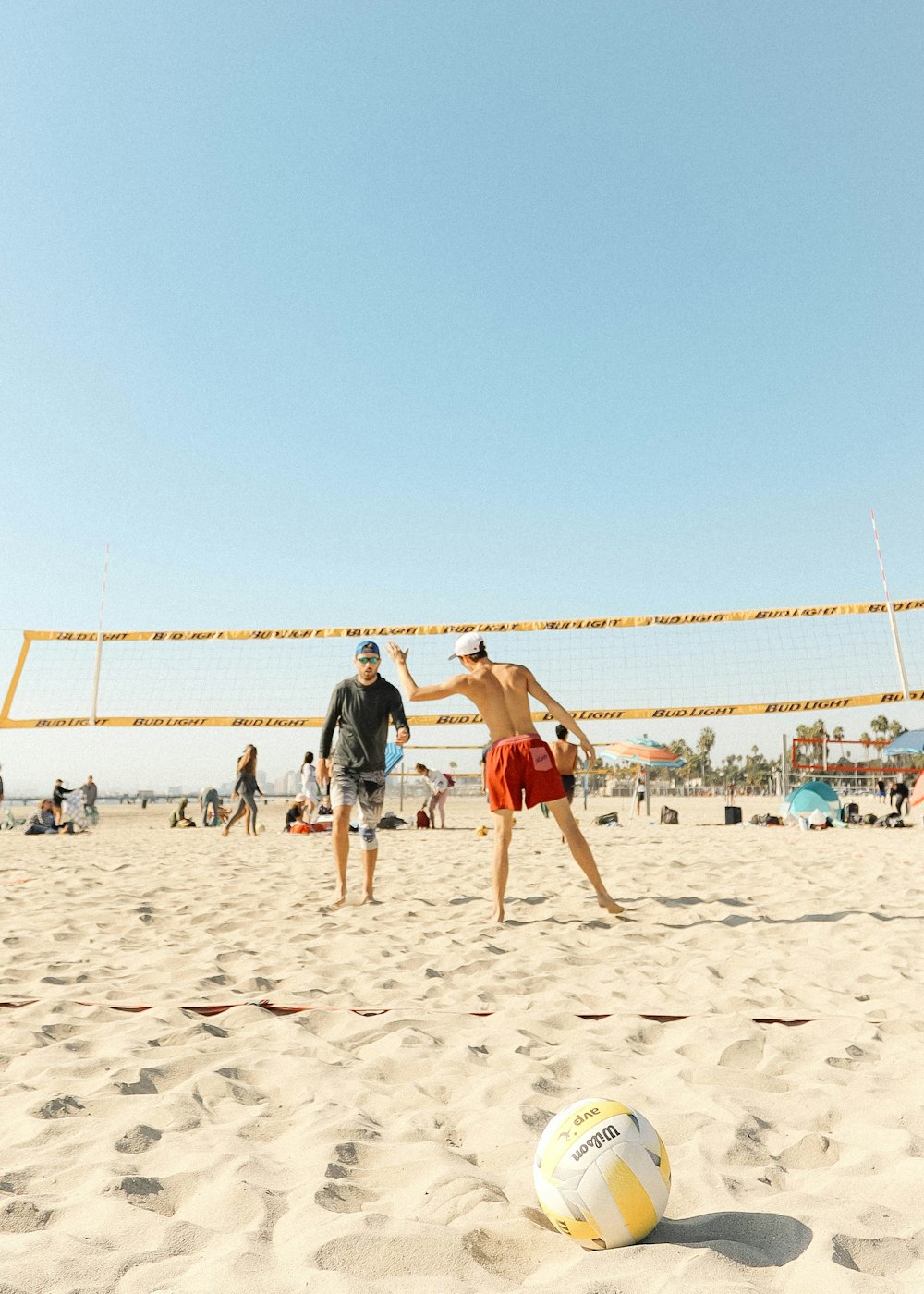 Imagem de pessoas jogando vôlei na praia.