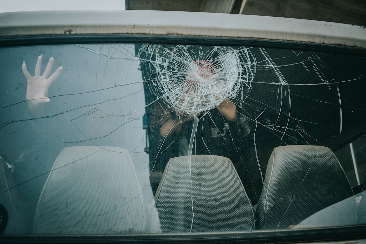 Person in a car with a broken windshield