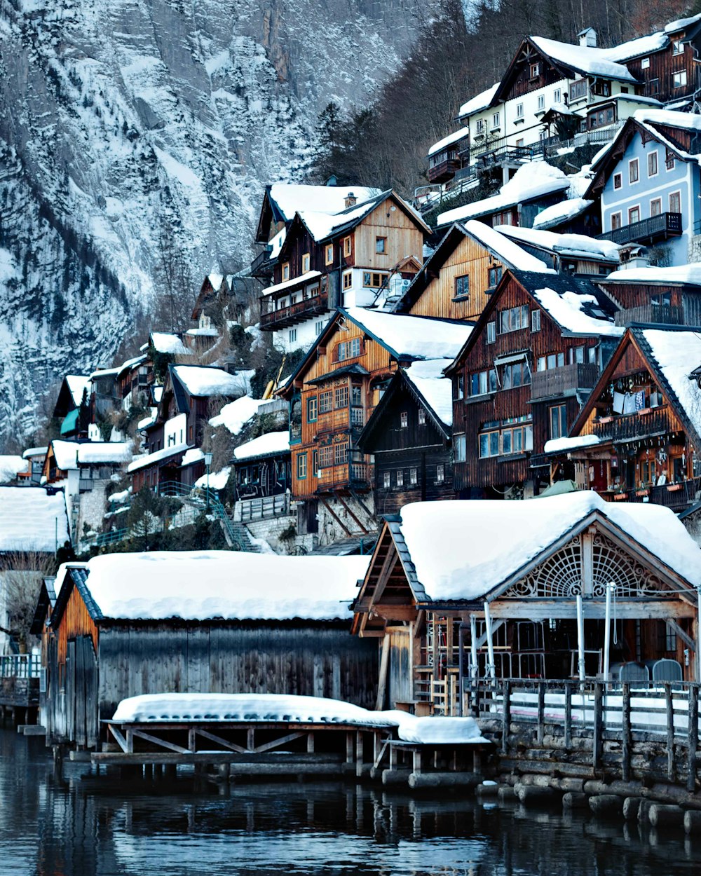 brown and white houses near snow covered mountain during daytime