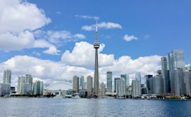 white and gray high rise buildings near body of water under blue sky during daytime