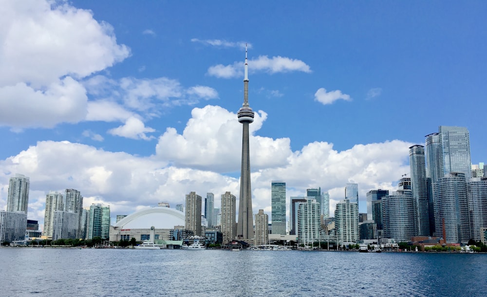 white and gray high rise buildings near body of water under blue sky during daytime