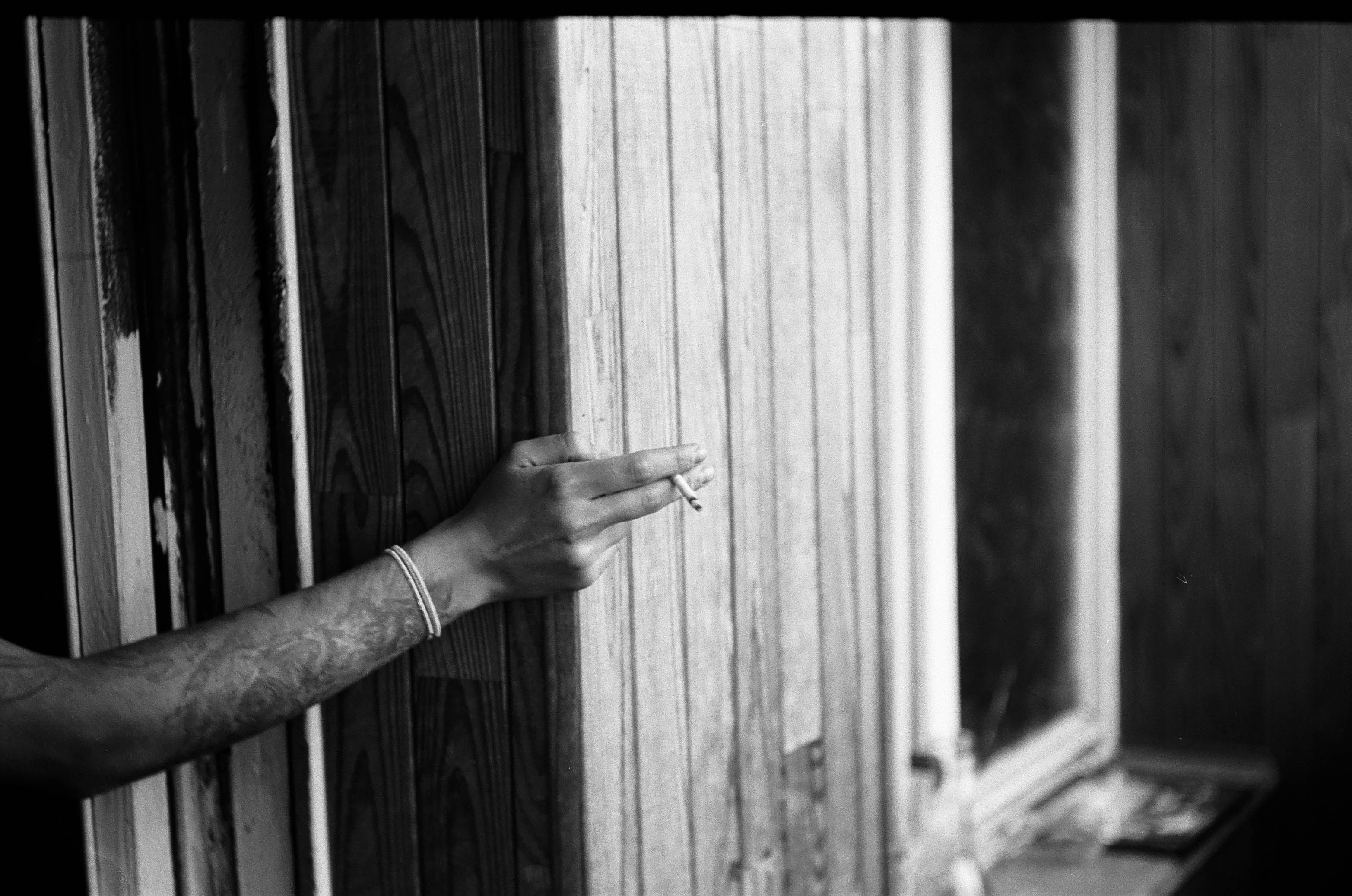 grayscale photo of person holding wooden door