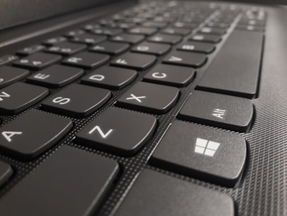 Close-up of a hand pressing Windows key and D on a keyboard to show desktop instantly.