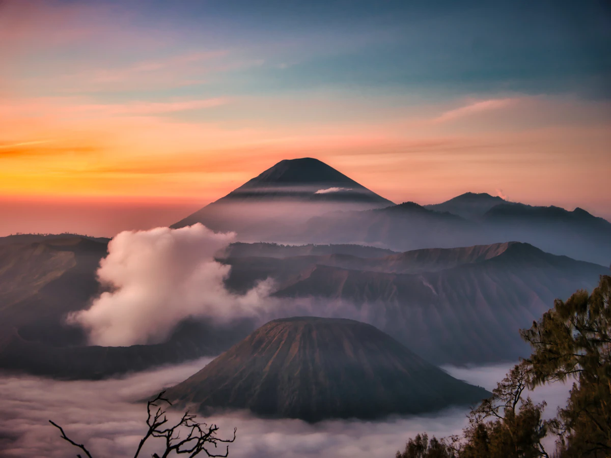 Sunrise over the Bromo caldera with mist filling the Sea of Sand and Semeru in the background