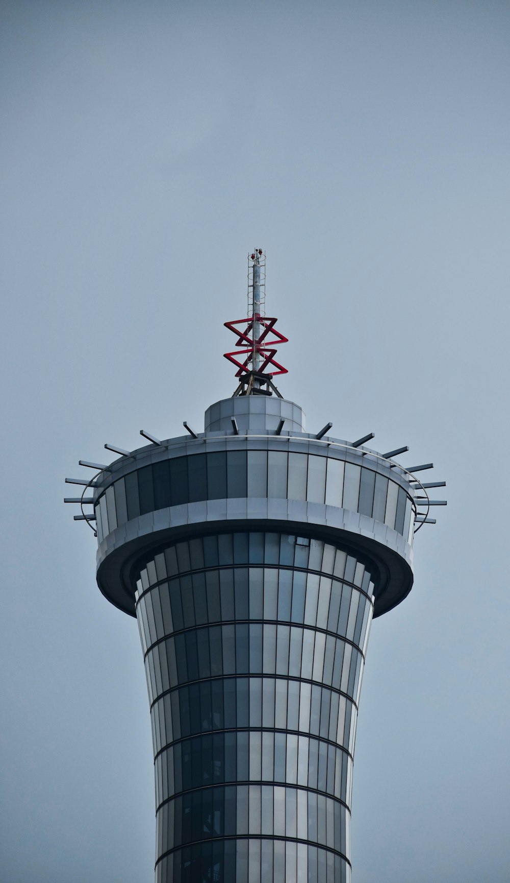 torre gris y roja bajo el cielo blanco durante el día