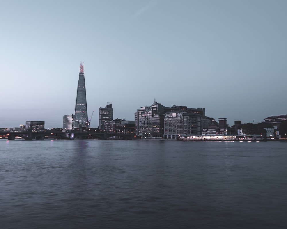 city skyline across body of water during night time