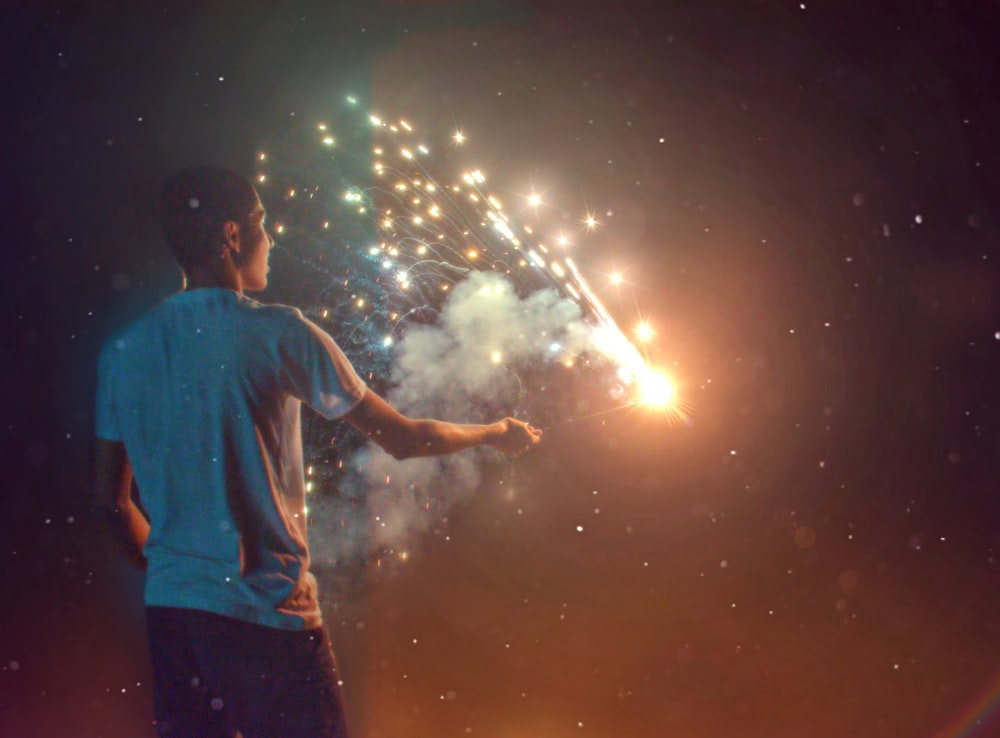 man in blue shirt holding fireworks