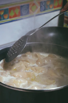 Slow-cooker filled with traditional sarmale, steam rising gently.